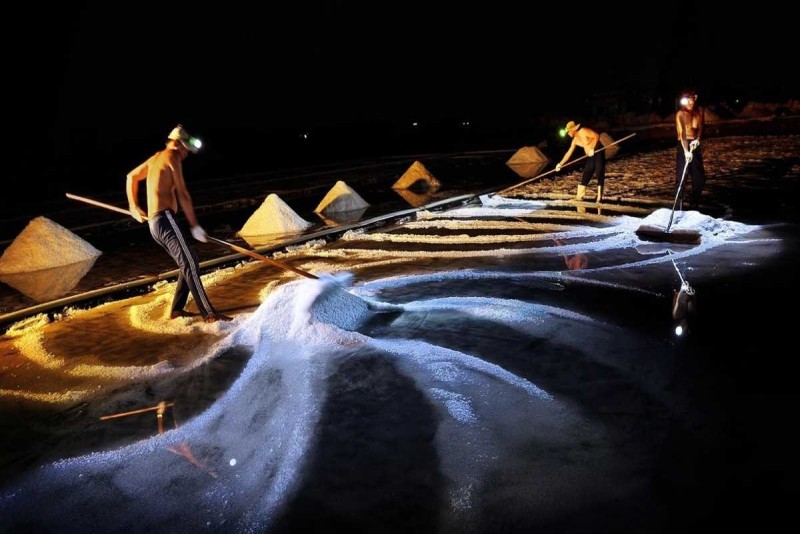 Salt Carrier at Sunset in Hon Khoi Salt Fields Salt worker carrying salt baskets during sunset at Hon Khoi Salt Fields, Nha Trang