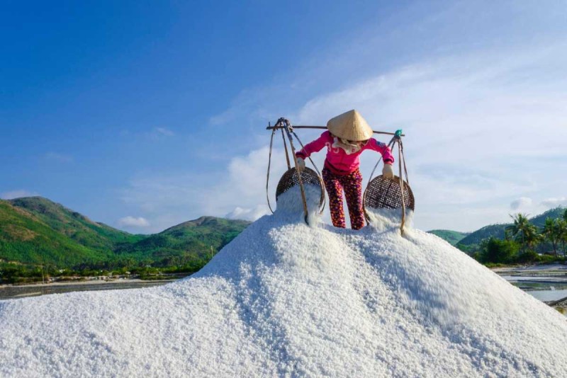 Salt Worker Balancing Baskets on Shoulder at Hon Khoi Salt worker balancing baskets filled with salt on shoulder at Hon Khoi Salt Fields