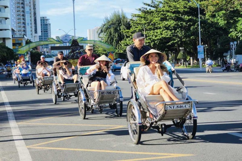 Tourists Enjoying Cyclo Ride in Nha Trang City Group of tourists taking a cyclo ride on the vibrant streets of Nha Trang city under sunny skies