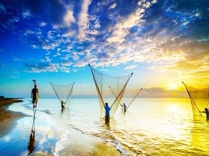 Ba Dong Beach in Tra Vinh Fishermen at Sunrise Fishermen at sunrise in Ba Dong Beach, Tra Vinh, casting nets into the sea.