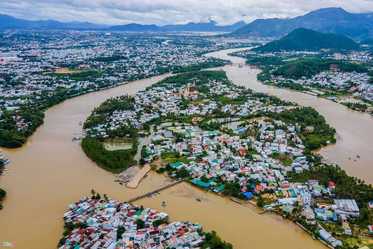 Aerial view of the Cai River winding through Nha Trang's countryside, showing the peaceful riverside villages and distant mountains.