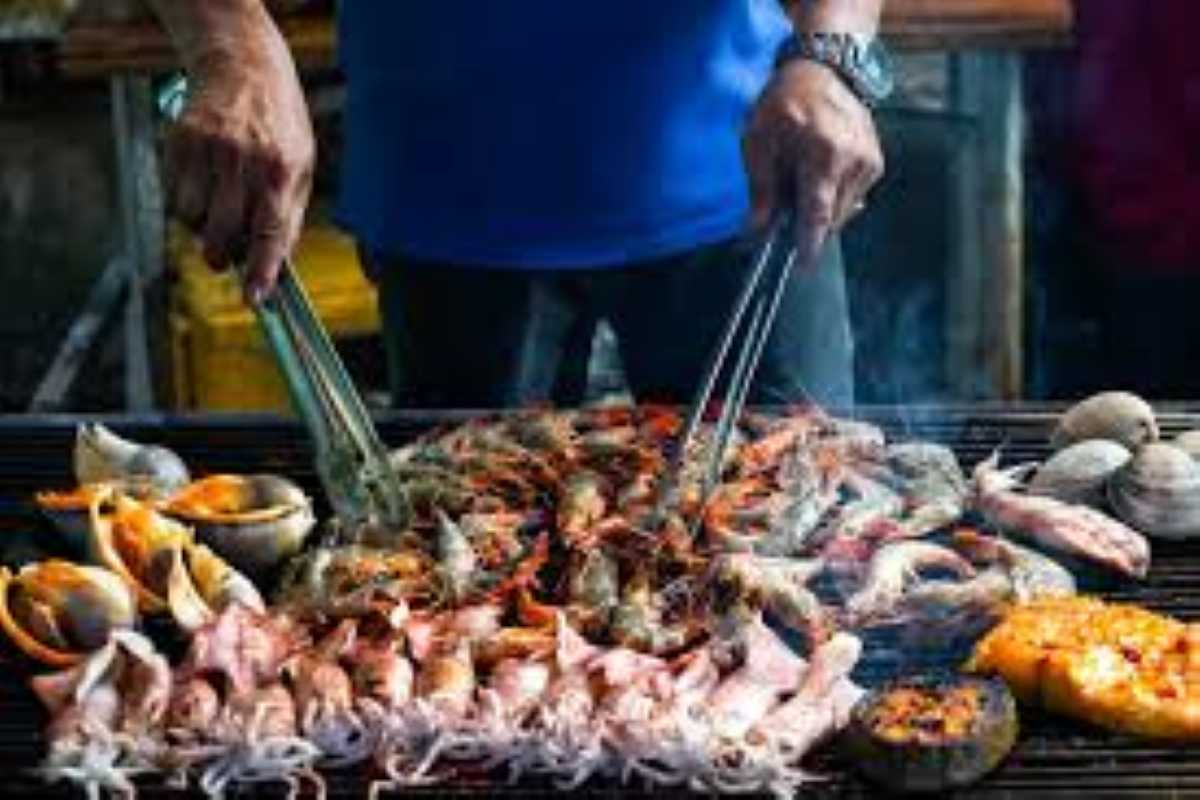 A variety of fresh seafood including squid, clams, and shrimp being grilled during the Island BBQ Dinner Phu Quoc.